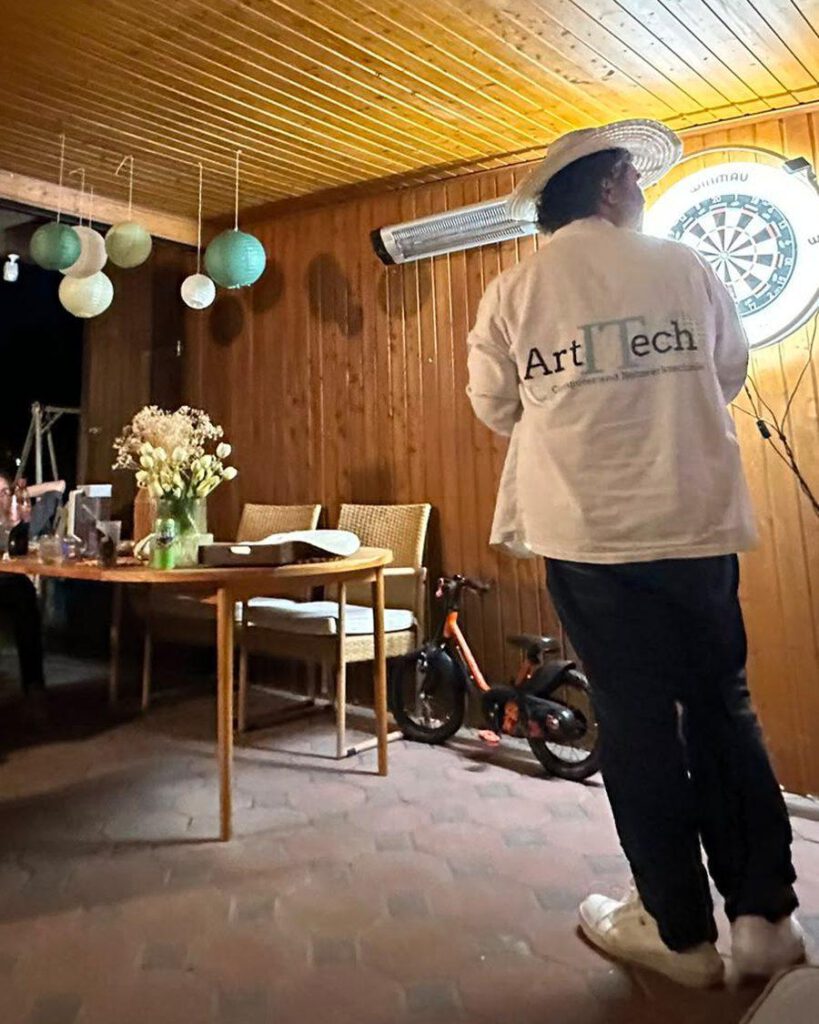 Artitech-Teammitglied im Firmenshirt bei einem Teamabend
